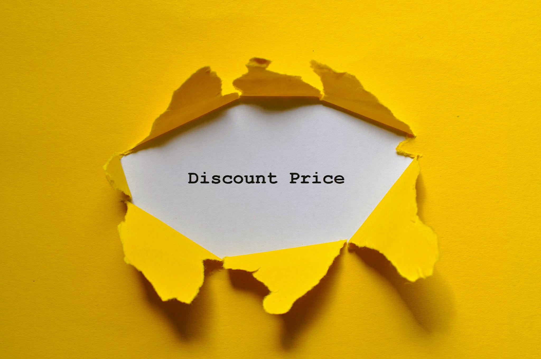 Torn yellow paper revealing 'Discount Price' text, ideal for sales promotions.