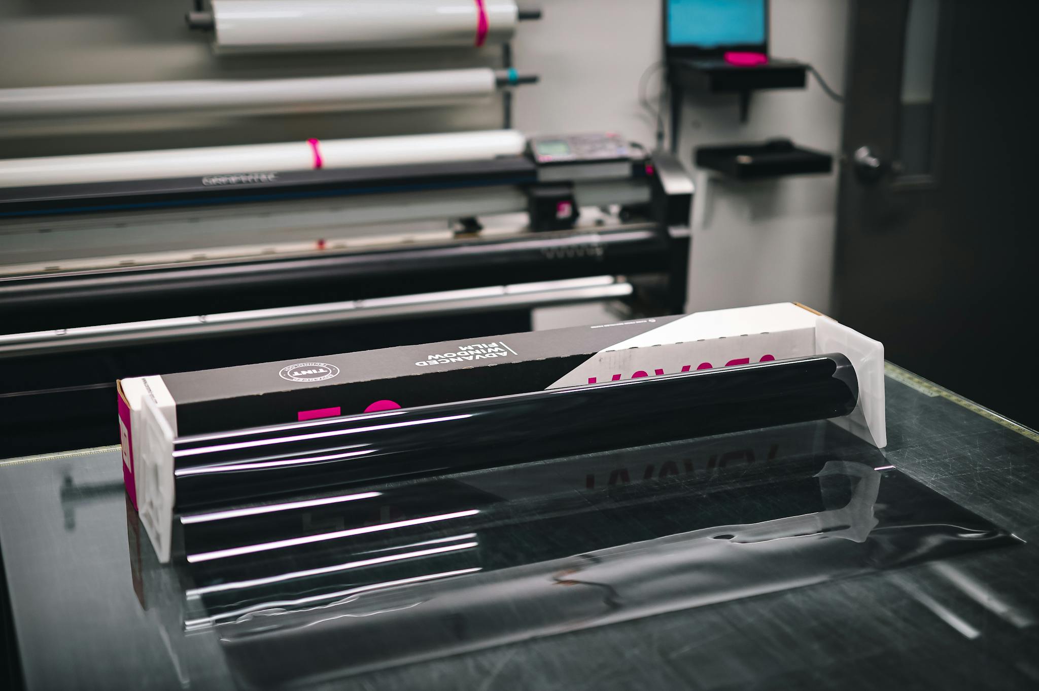 A glossy roll of vinyl material inside a modern print shop, ready for use in creating projects.